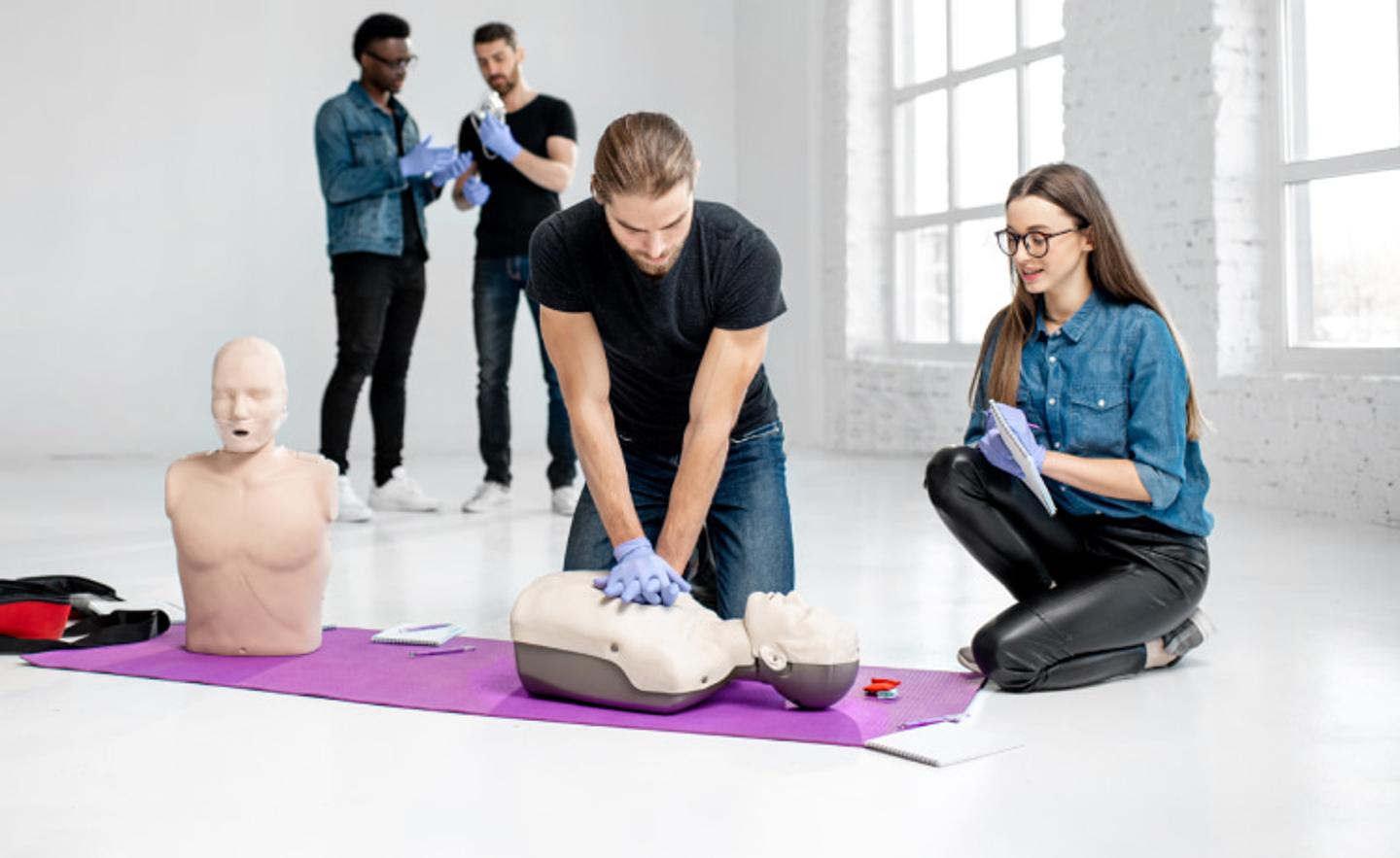 A woman teaching CPR techniques to a student