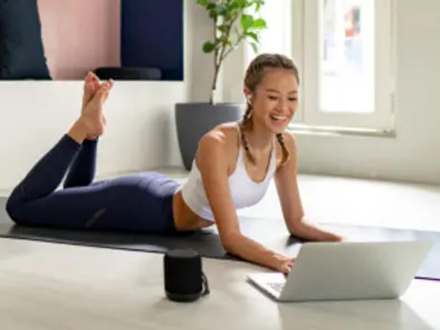Yoga Instructor leading a class in front a laptop