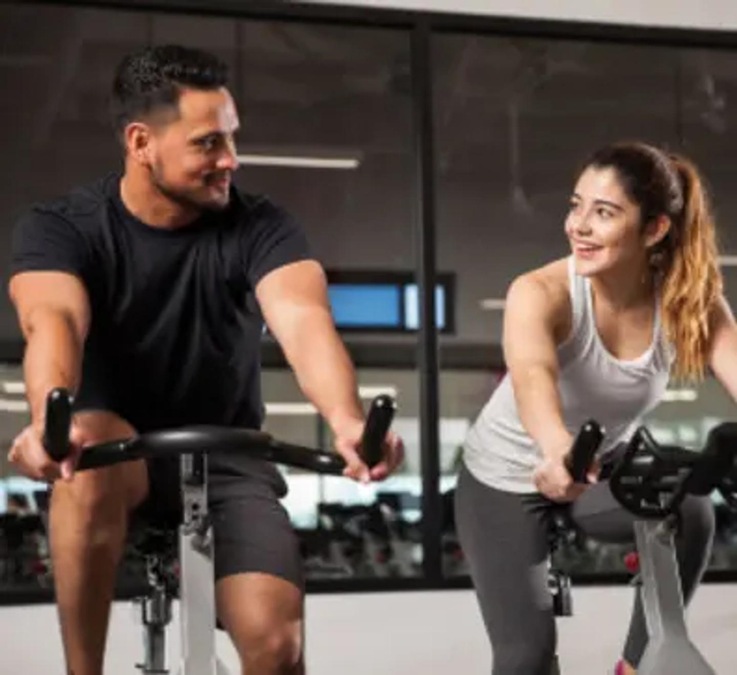 Indoor Cycling Instructor helping client at a gym