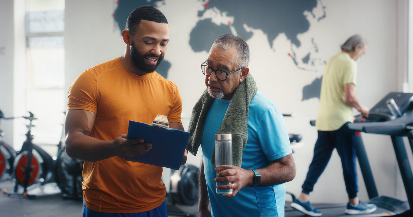 Trainer and client reviewing progress notes together on a clipboard